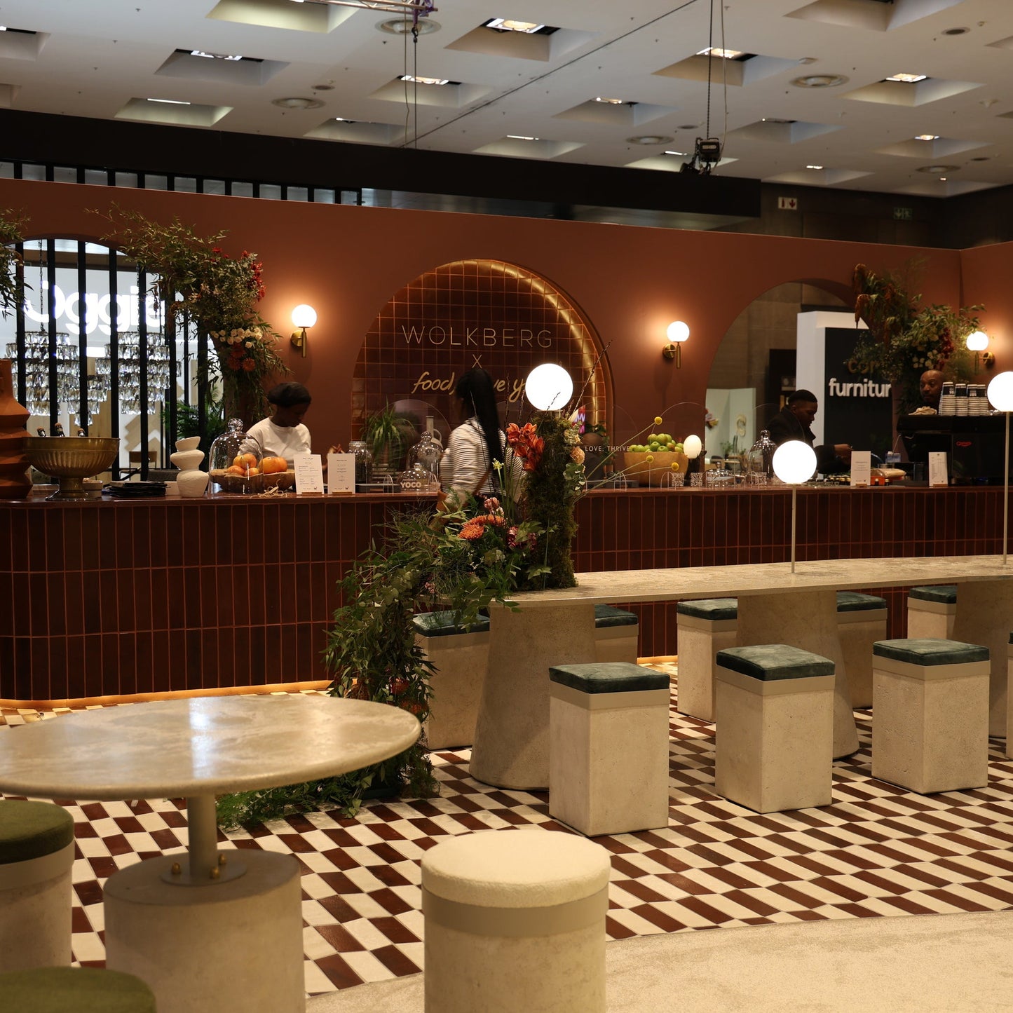 Modern interior design with a bar area, stools, and decorative plants.