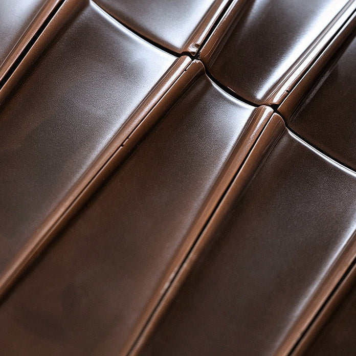 
                  
                    Close-up of dark brown tiles with stitched panel seams and a glossy finish.
                  
                